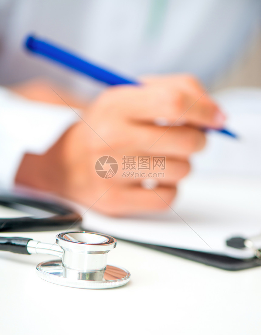 医生的手和一张桌子空白工作文档药品诊所白色写作药片笔记处方图片