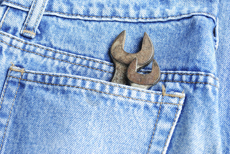 灰色牛仔裤口袋的断腿套 重点放在工具上工业金属维修工作织物扳手棉布建造工人纺织品背景图片