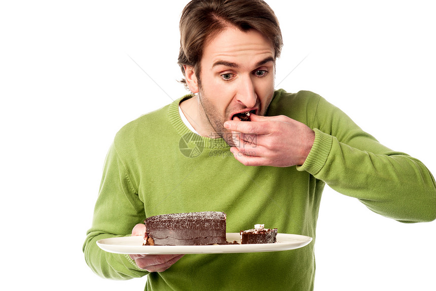 年轻人在吃巧克力蛋糕时匆忙图片