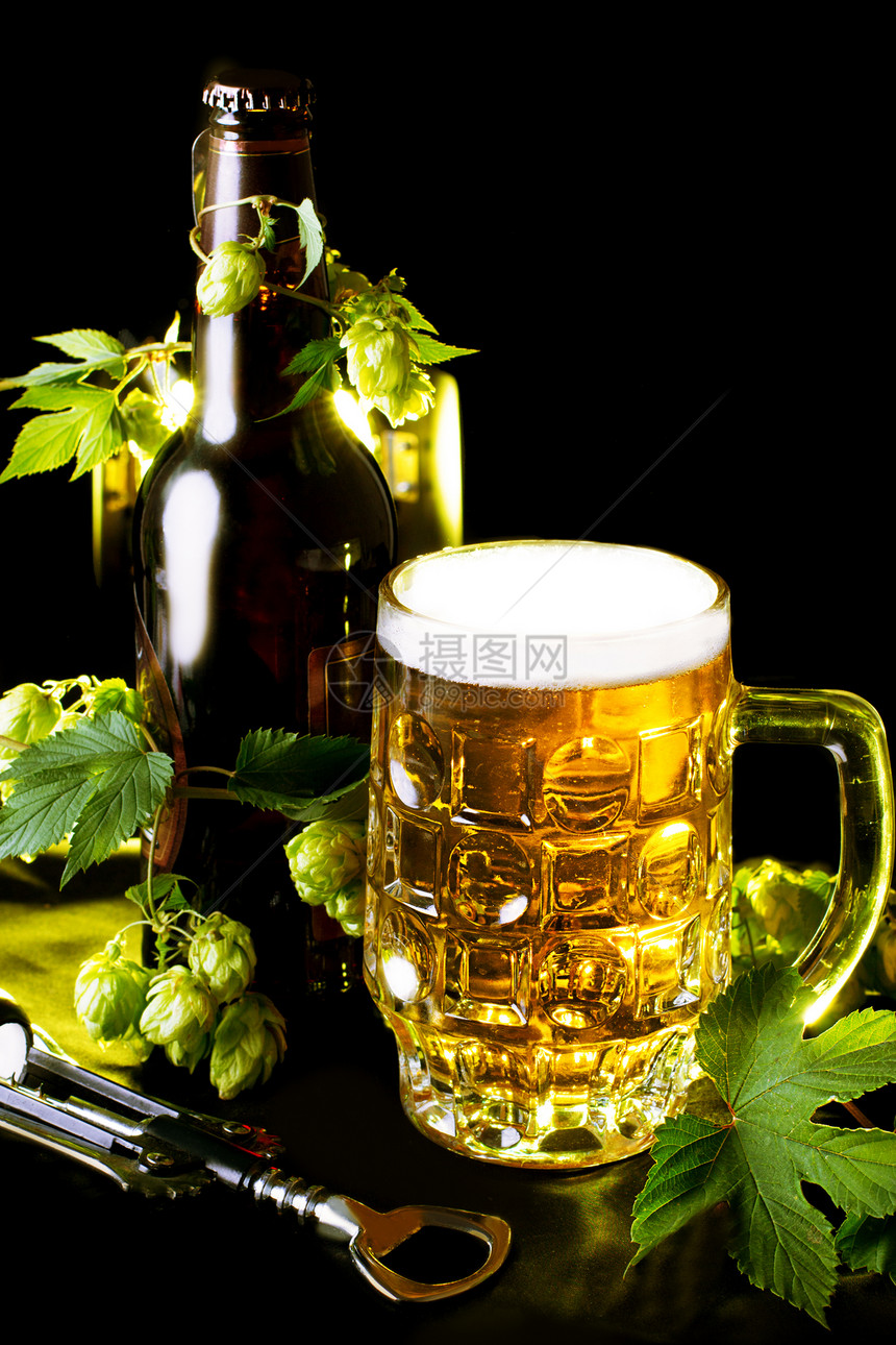 金啤酒 瓶子和开瓶器的酒叶气泡生活小路玻璃投手啤酒厂植物庆典桌子啤酒图片