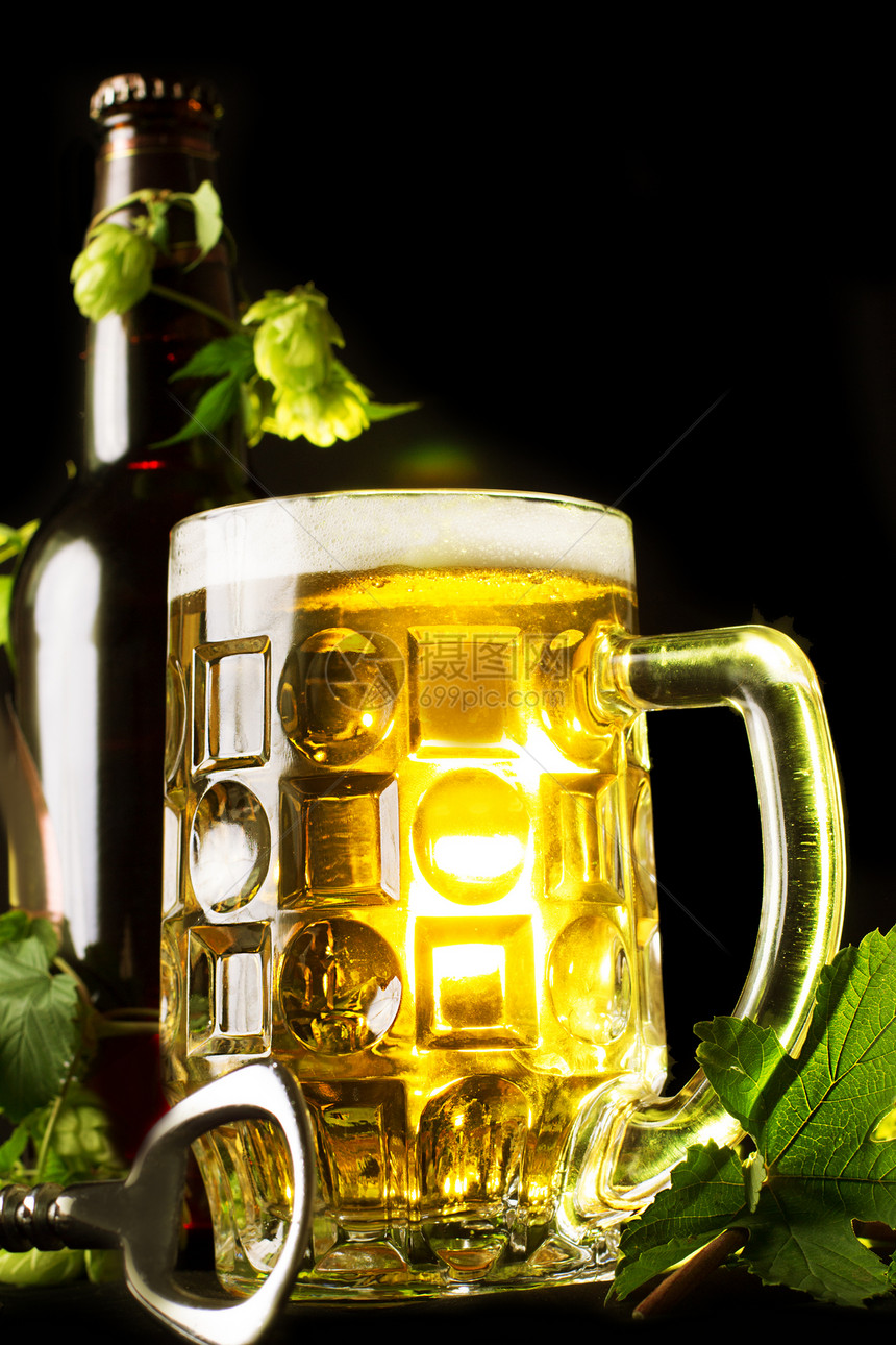 金啤酒 瓶子和开瓶器的酒叶气泡泡沫小路饮料烧杯生活啤酒树叶玻璃酒吧图片