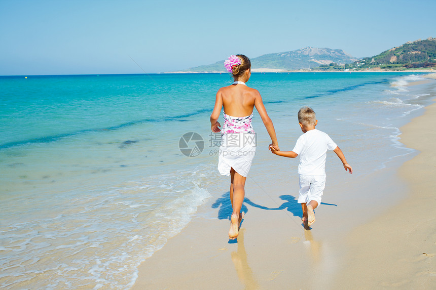 海滩上可爱的男孩女孩太阳热带跑步快乐情调女孩假期男生孩子喜悦图片