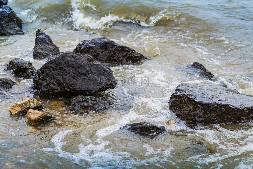 海浪冲刷在海岸的石头上图片