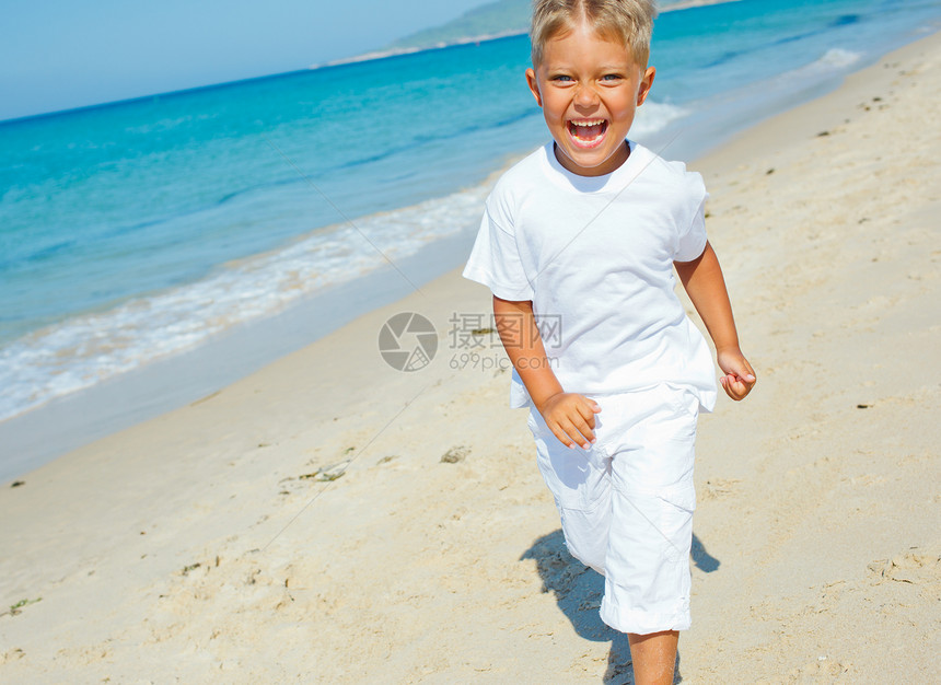 海滩上可爱的男孩异国跑步海景情调海洋幸福假期微笑眼镜支撑图片