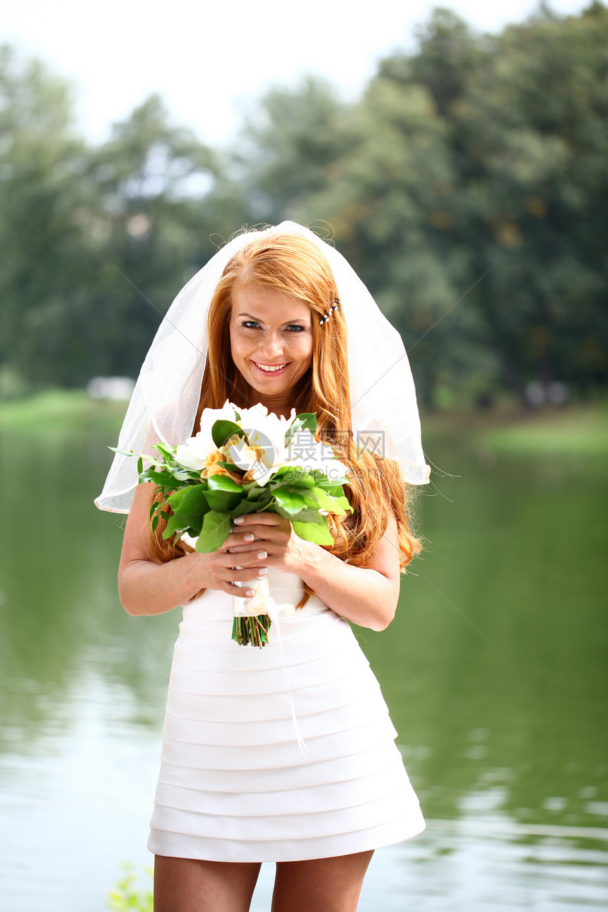 穿着婚纱的美丽红发新娘婚姻公园快乐花朵面纱女士裙子女孩女性花束图片