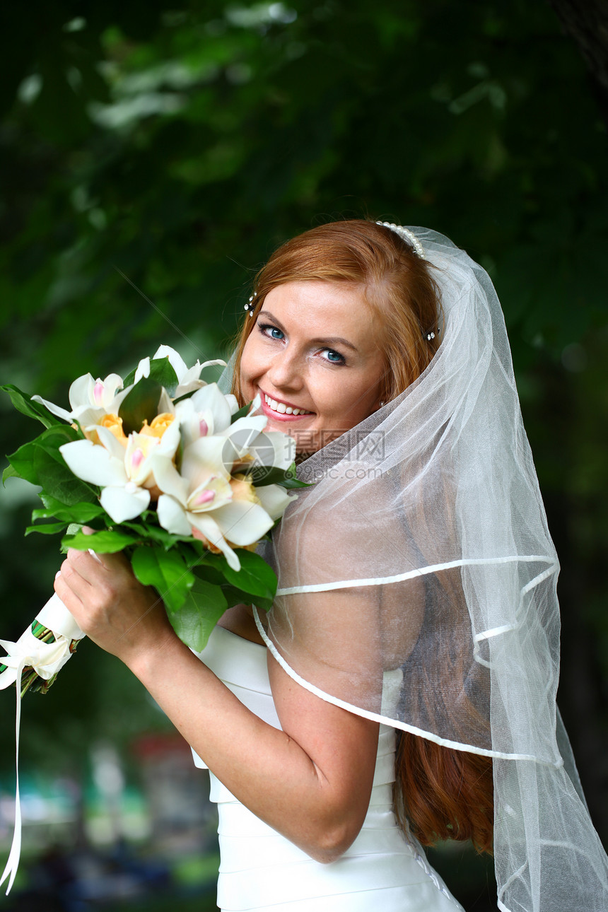 穿着婚纱的美丽红发新娘花朵公园婚姻快乐女性幸福女孩派对礼服面纱图片