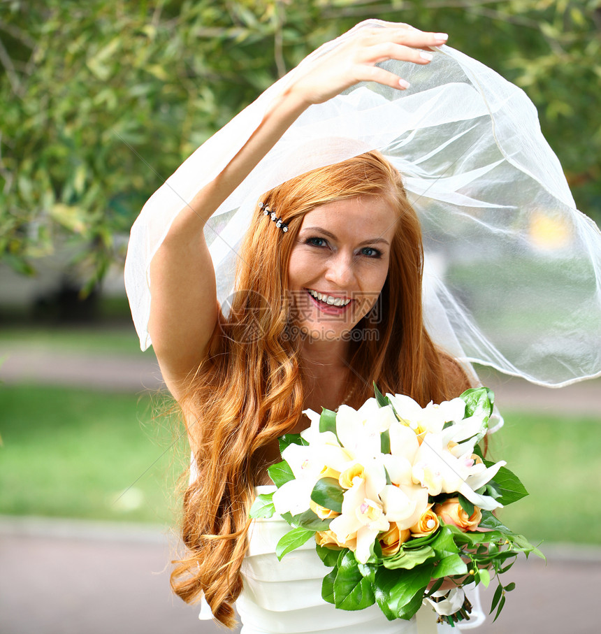 穿着婚纱的美丽红发新娘女孩婚礼青年公园派对面纱礼服快乐花朵裙子图片