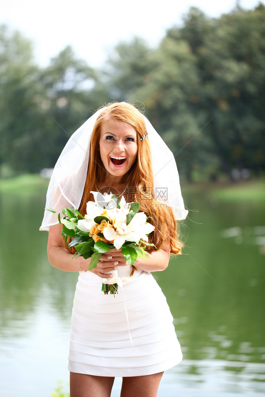 穿着婚纱的美丽红发新娘公园花朵快乐派对女孩幸福面纱女士礼服婚姻图片
