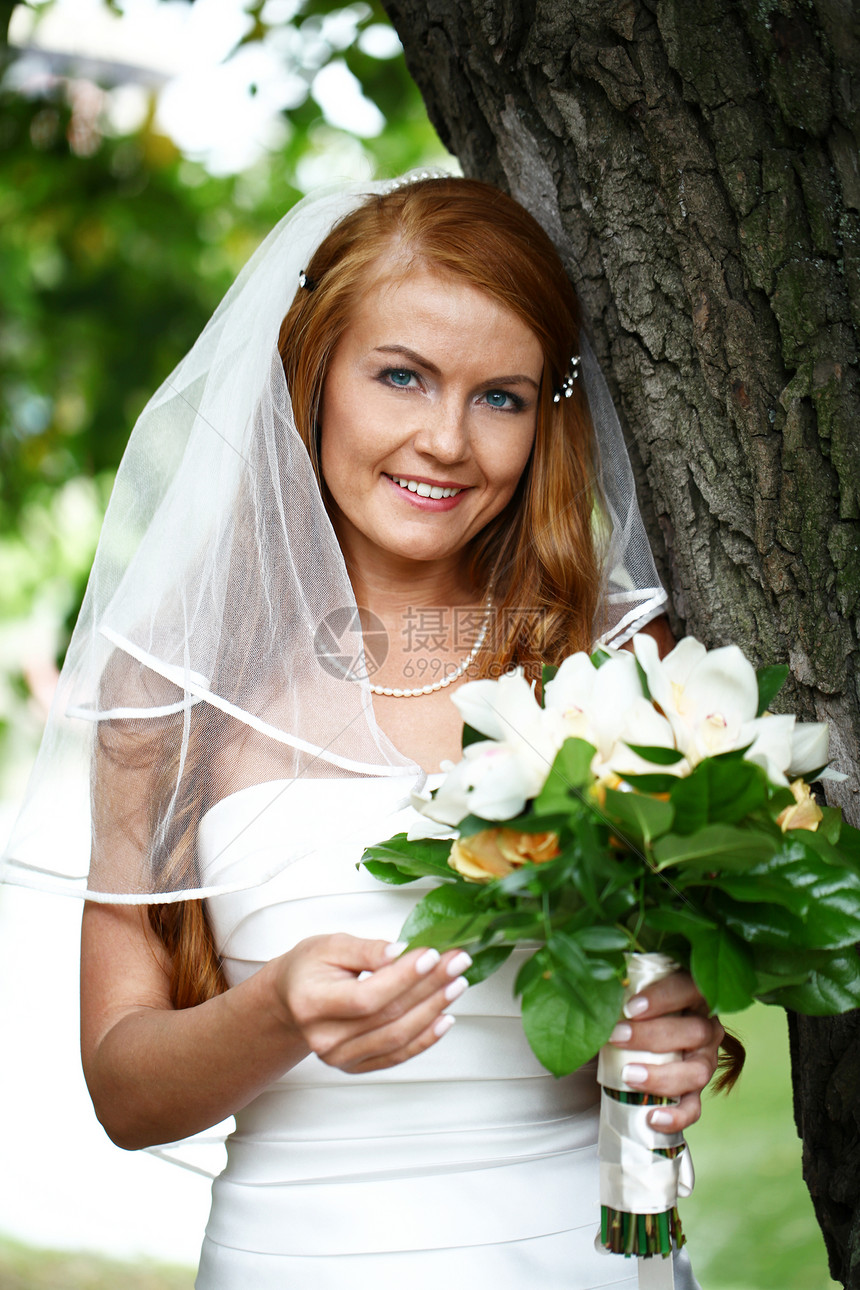 穿着婚纱的美丽红发新娘微笑女士派对公园花朵婚礼婚姻青年裙子礼服图片