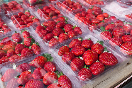 草莓包装中的草莓红色团体摄影塑料水果市场背景图片