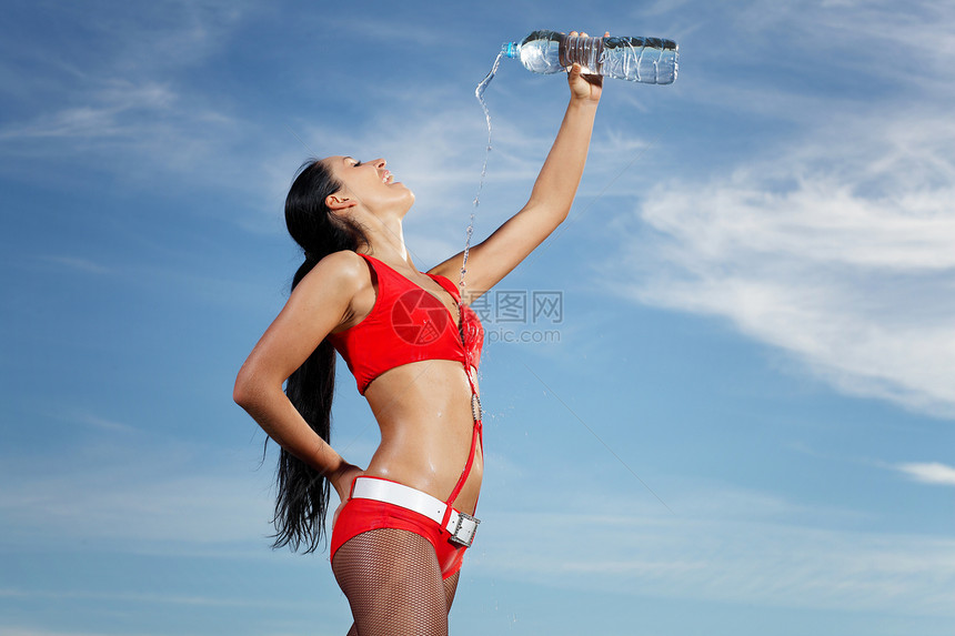 年轻女运动女青年 喝一瓶水健身房矿物工作室头发毛巾瓶子成人女性锻炼运动员图片