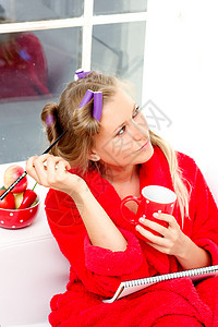 穿红袍的女孩咖啡金发女郎记事本记录成人浴衣女性杯子时间表勺子背景图片
