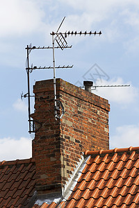 旧烟囱上的TV空中飞行天线瓷砖房子天空接待背景图片