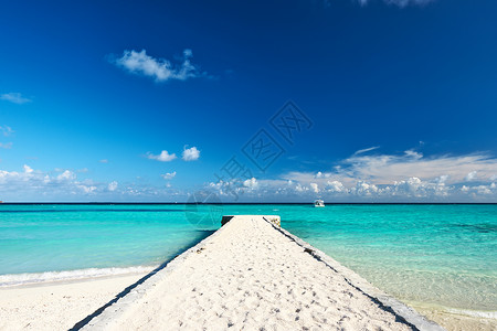 浪沙美丽的海滩和码头热带海洋奢华平台海景海岸线风景蓝色天空假期背景