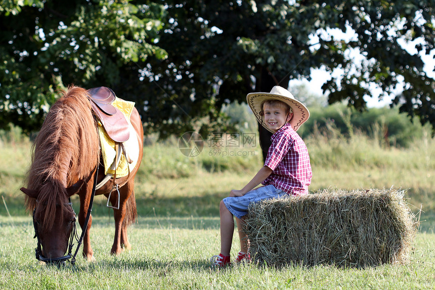 快乐的男孩和马匹在农场上图片