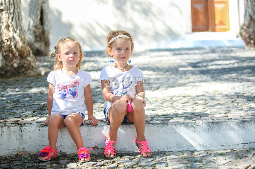 坐在桑托里尼Emporio老希腊村街头的年轻迷人女孩旅行蓝色建筑衣服休息家庭商场农村传统房子图片
