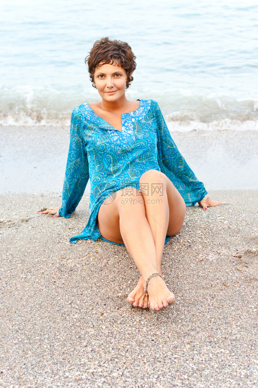 在海滩上穿蓝裙子的女人天空棕褐色成人头发女士微笑幸福蓝色白色假期图片