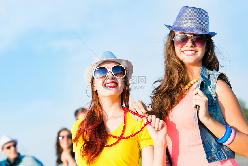 两个年轻女友玩得开心女性天空拥抱友谊会议闺蜜太阳镜派对晴天乐趣图片