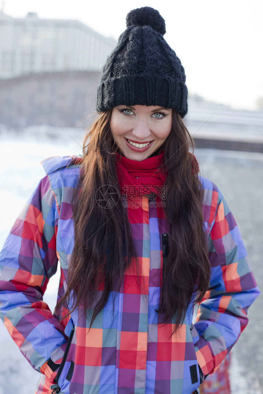 冬季城市背景中一位年轻女性的肖像微笑享受大衣衣服手套外套女士天气快乐黑发图片