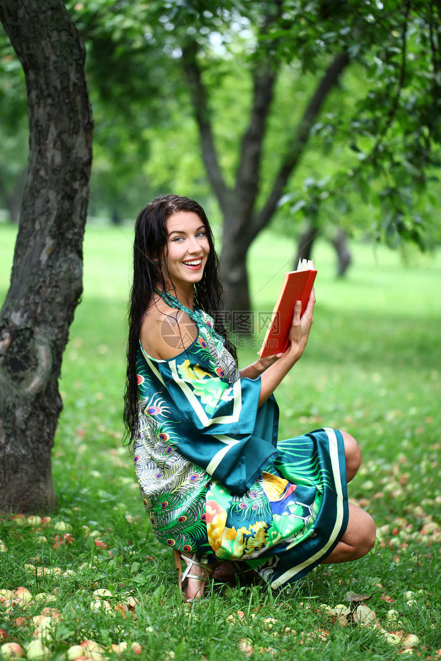 在公园看书的金发女孩阳光微笑学生女性投标青少年享受女士阅读金发女郎图片