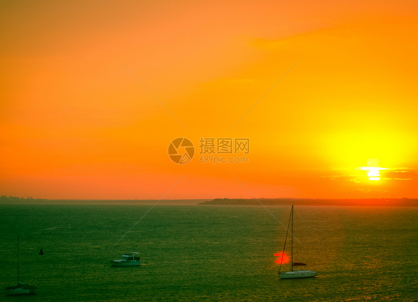 美丽的海日落游艇橙子热带海浪旅行太阳航行反射海洋帆船图片