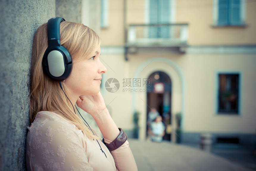 听音乐的美丽金发美女城市潮人音乐金发女郎街道女士太阳镜玩家幸福耳机图片