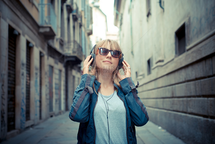 听音乐的美丽金发美女城市女士玩家街道太阳镜音乐金发女郎耳机潮人冒充图片