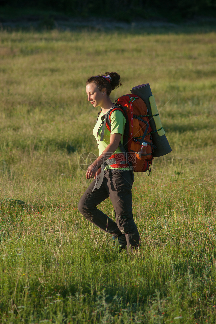 在实地微笑的快乐妇女游客农村旅行植物学远足者运动一个女孩冒险喜悦花朵图片