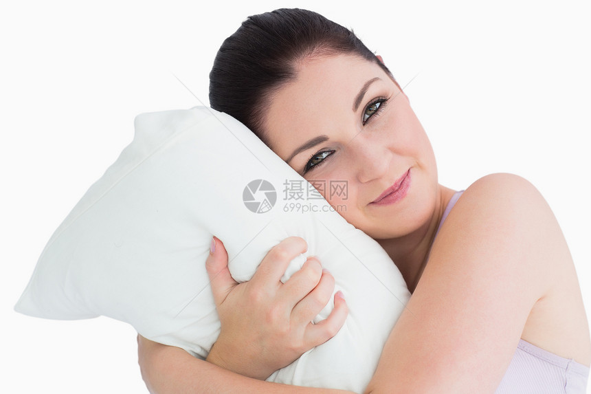 微笑的女人醒在枕头上黑发女士棕色黑眼睛头发睡衣眼睛女性软垫快乐图片