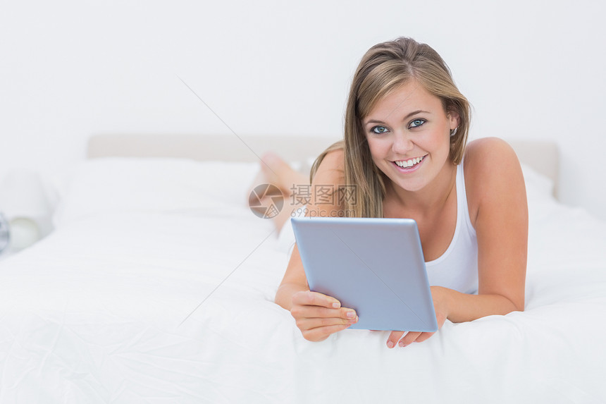 微笑的金发女人 用她的平板电脑Pc图片
