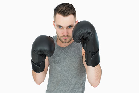 拳击姿势中年轻人的肖像拳击手姿态男人拳头对抗男性挑战手套运动背景图片
