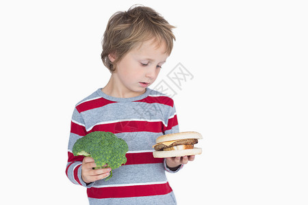男孩拿着西椰菜和汉堡金发女郎蔬菜条纹男性男生浅色头发金发童年背景图片