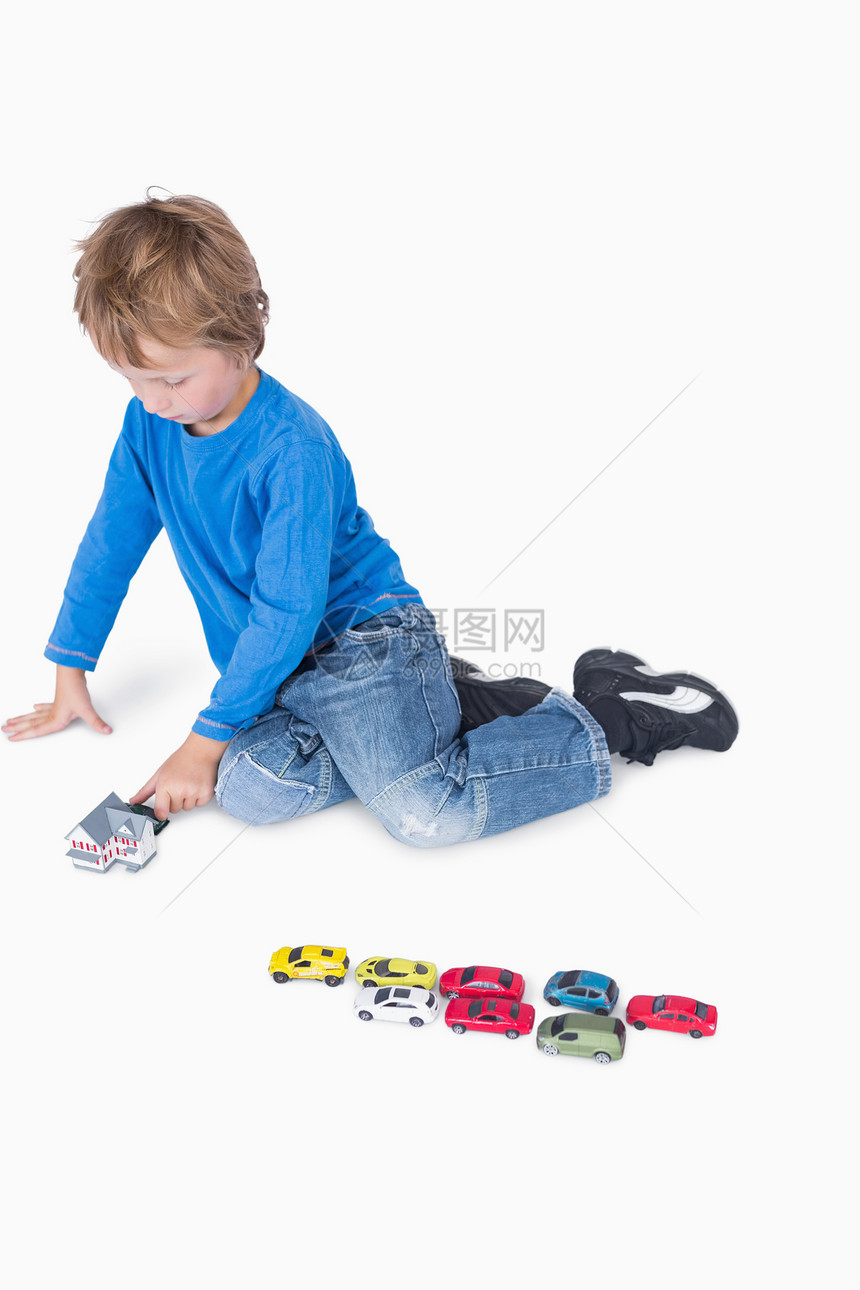 玩游戏屋和玩具汽车的年青男孩图片