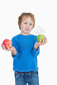 年轻男孩的肖像 握着绿色和红苹果背景图片