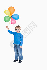 年轻男孩拿着一捆气球的肖像背景