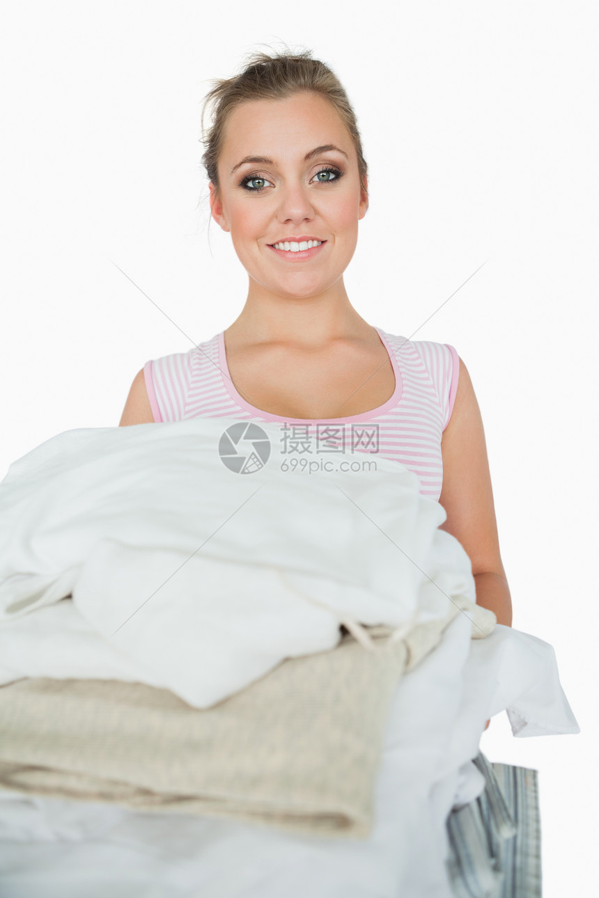 带着一叠衣服的微笑着的女人的肖像头发金发女士打扫金发女郎洗衣店家务家庭杂务家政图片