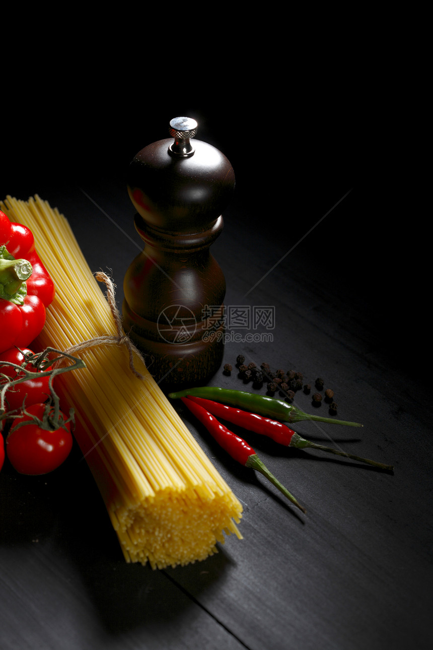 黑桌上的面食成分桌子香料蔬菜盘子食物脚轮胡椒美食辣椒面条图片