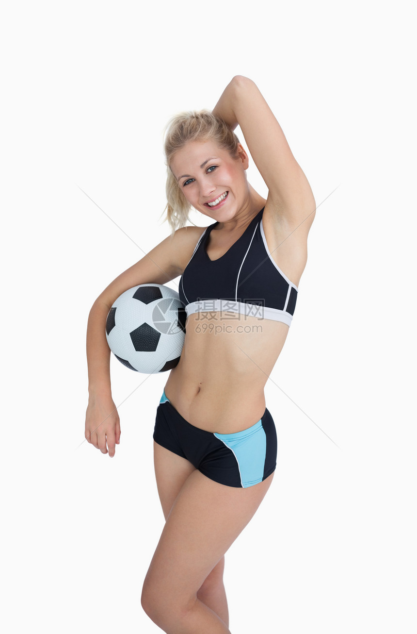 足球在白色背景上摆姿势的体育女运动员图片