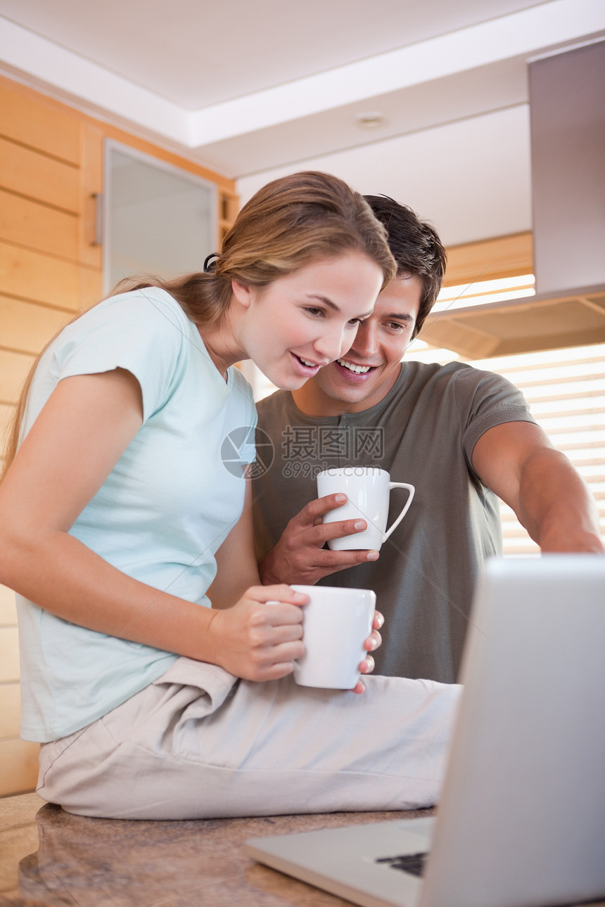 夫妇在喝咖啡时使用笔记本电脑女士技术咖啡杯男性夫妻咖啡房子微笑家庭生活男人图片