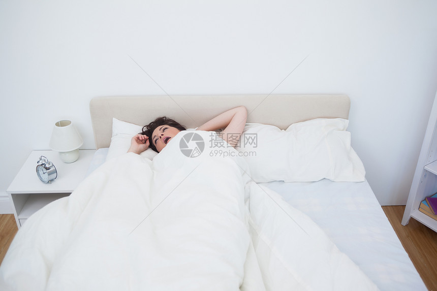 女人在床上打哈欠床单房子卧室女性桌子家庭生活女士羽绒毯子图片