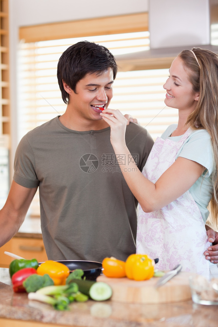 在厨房快乐的一对情侣男朋友台面夫妻平底锅烹饪准备勺子女朋友食物男性图片