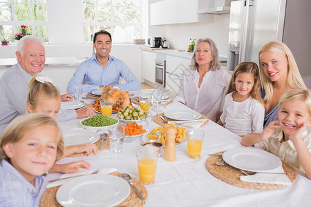 家人一起吃晚饭父母祖父母儿子男生祖父父亲橙汁孙子女士女孩背景图片