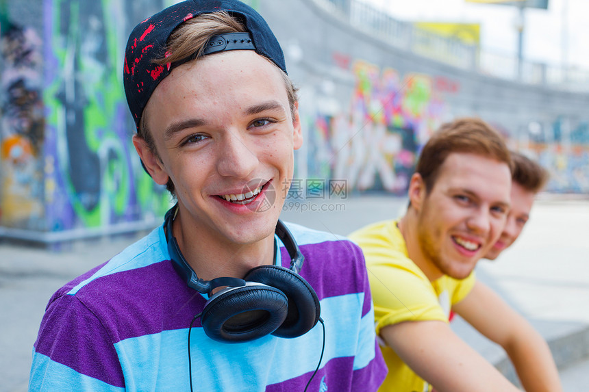 三个年轻朋友幸福快乐朋友们青少年太阳镜衣服滑板街道蓝色男性小伙子季节图片