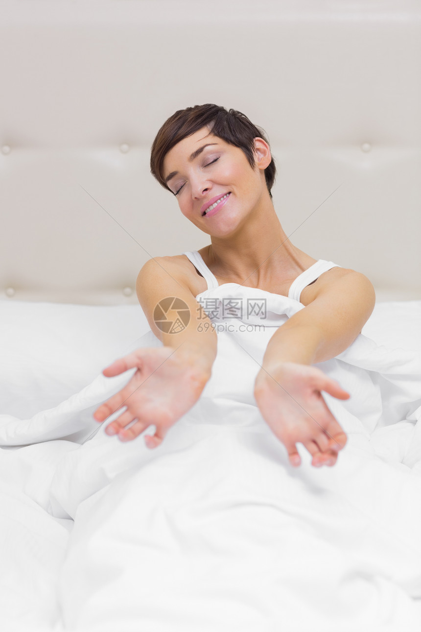 女孩在床上伸展坐垫卧室羽绒被房间短发唤醒女士说谎棕色床单图片