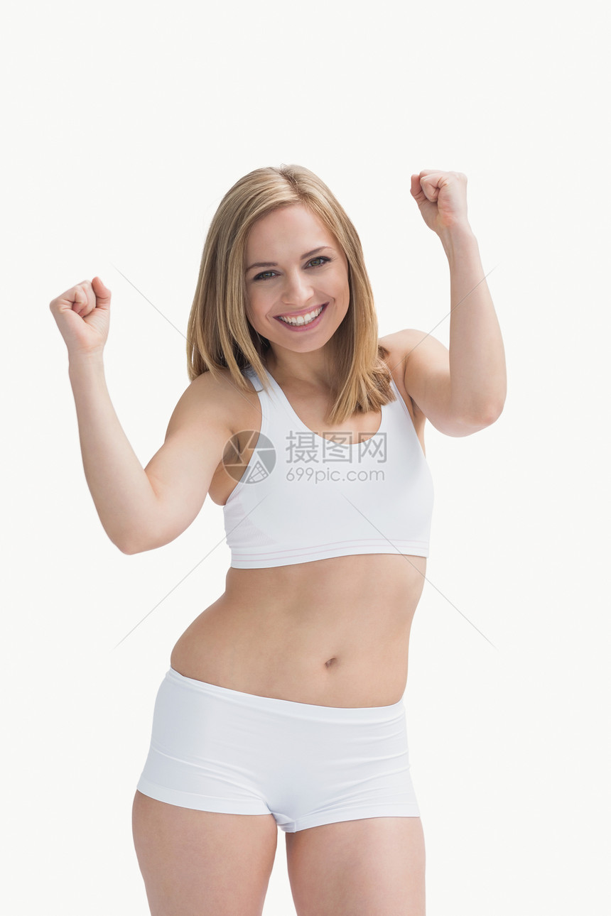 一名身穿运动服兴奋的年轻女子的肖像闲暇浅色拳头身体运动微笑头发金发幸福女士图片