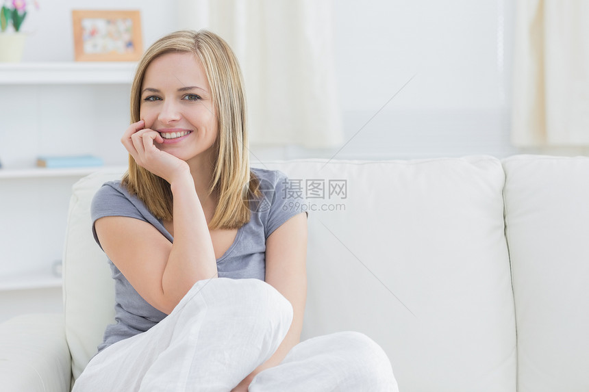 坐在沙发上的放松女人的肖像头发浅色女士客厅下巴房子长椅金发幸福闲暇图片