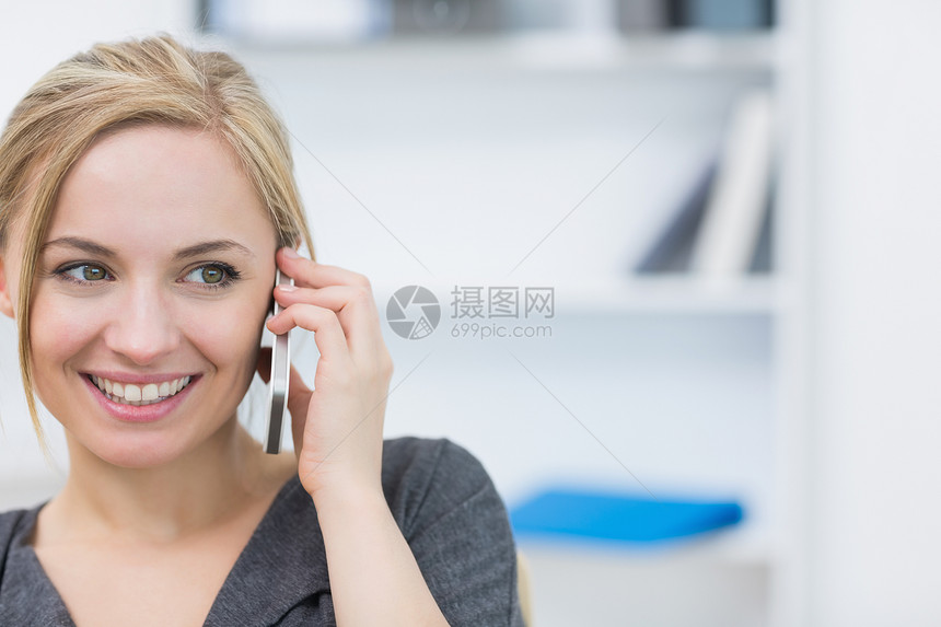 在办公室使用移动电话的女企业主近身检查图片