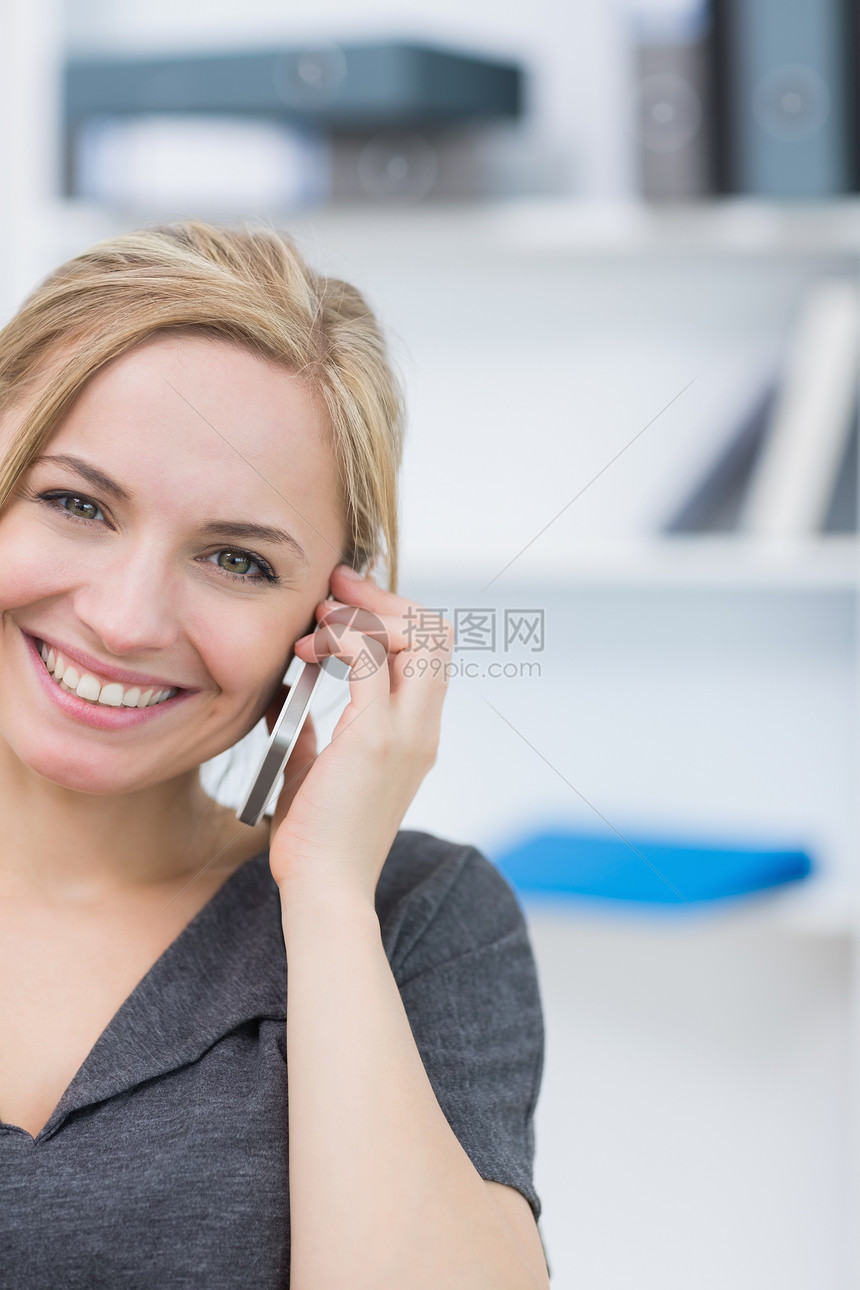 办公室使用移动电话的笑脸商业女商务人士图片