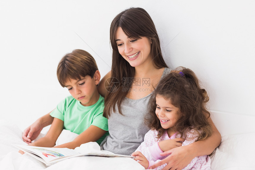 母亲和她的孩子在读一本故事书图片