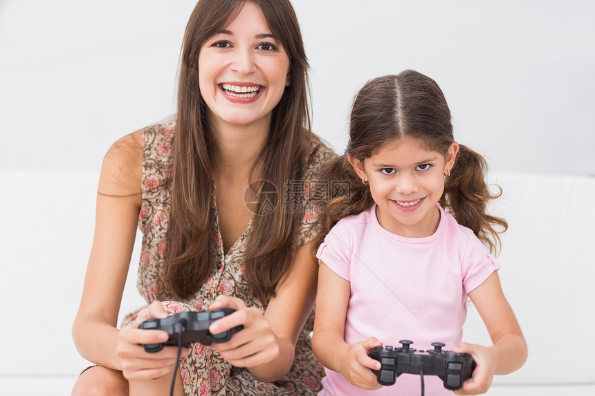 快乐的妈妈和女儿玩电子游戏图片